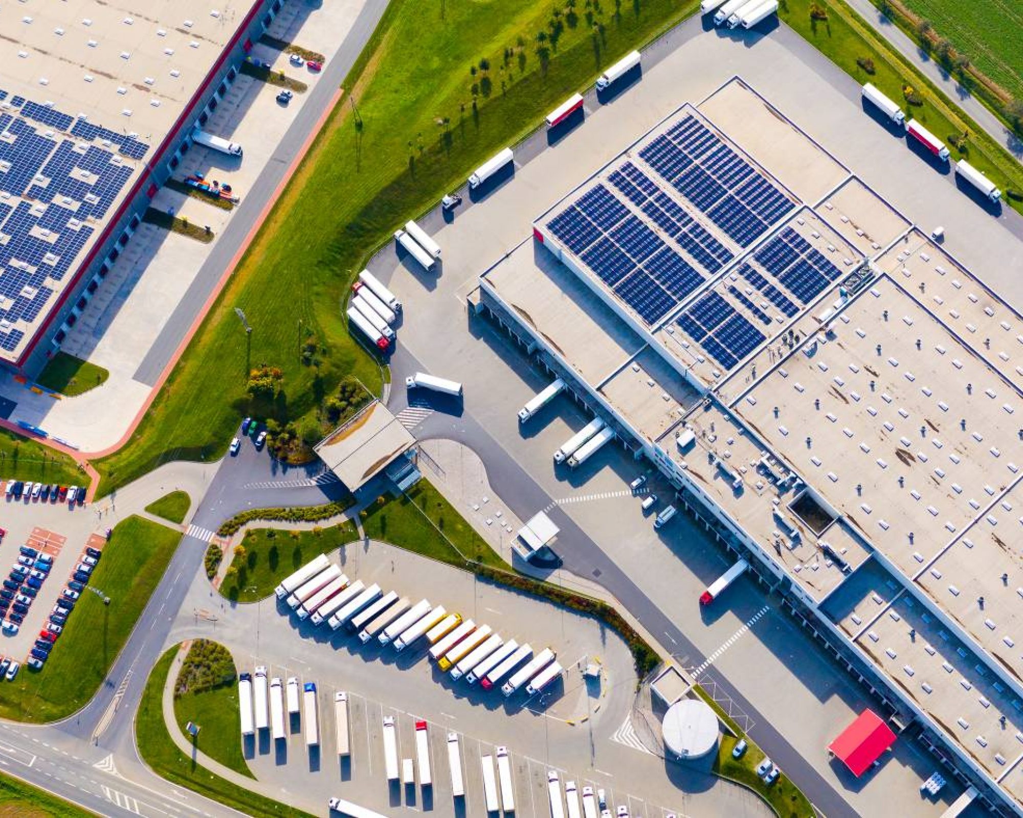 Industry with low carbon footprint. Industrial warehouses with solar panels on the roof. Technology park and factories  from above